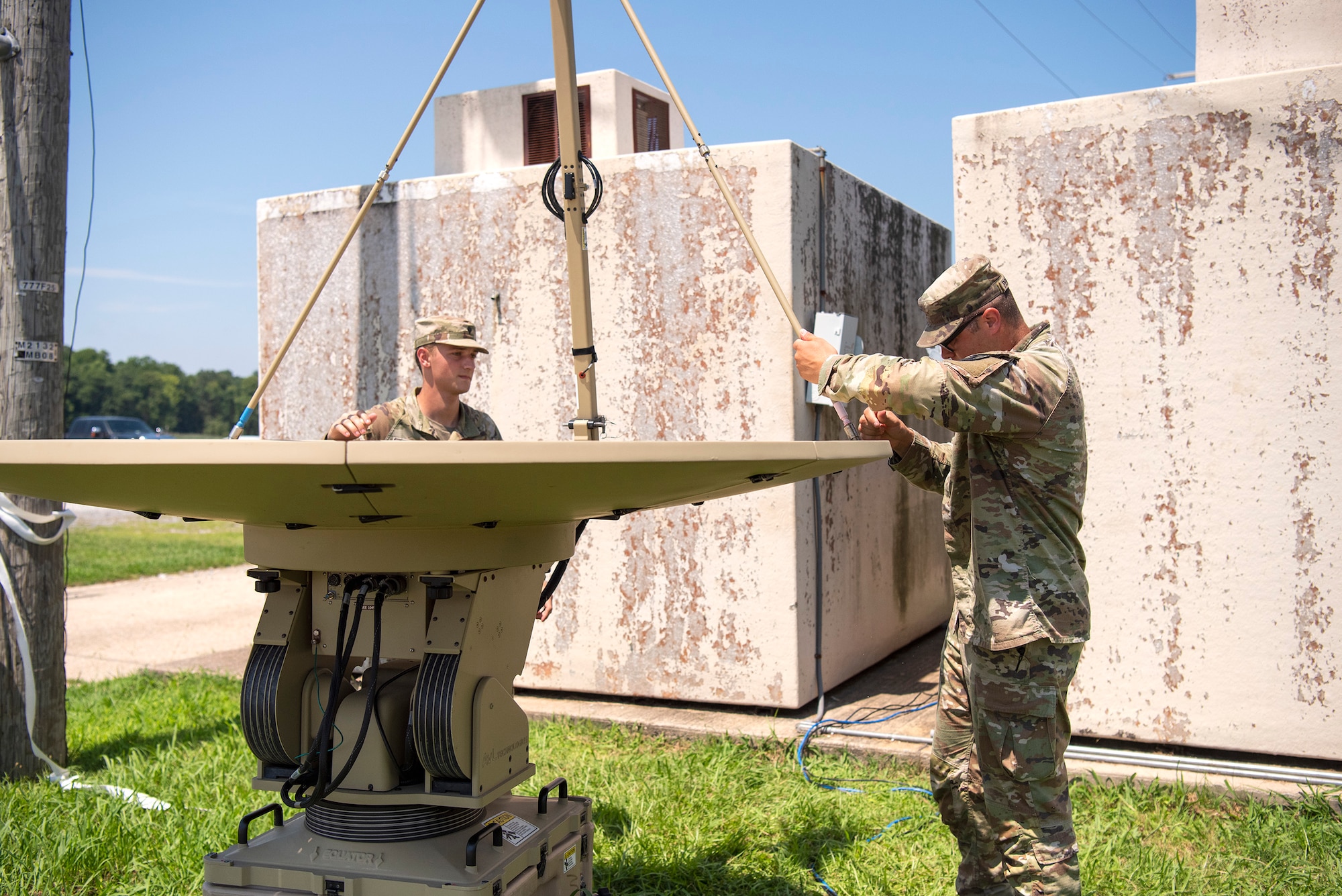 Two Soldiers set up satellite dishes at Joint Base Langley-Eustis, Virginia, Aug. 4, 2022.