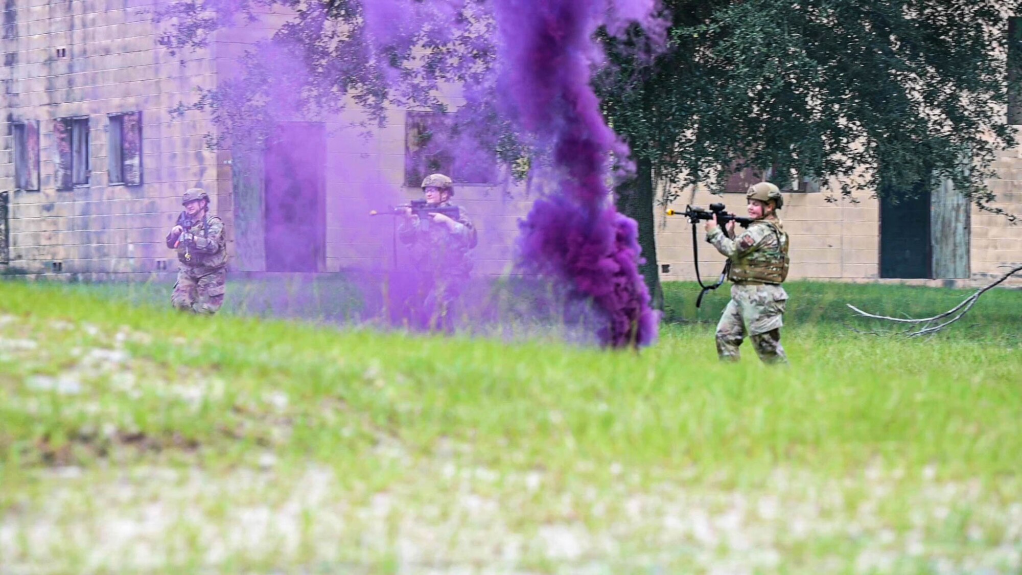 Photo of Airmen charging towards a building