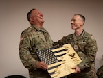West Virginia Army National Guard Col. Mark B. Houck receives a gift of appreciation for his time as commander of the Army Interagency Training and Education Center (AITEC) from Lt. Col. Robert Luther during a ceremony at AITEC headquarters in St. Albans, West Virginia, Aug. 9, 2022. Houck relinquished command of AITEC to Lt. Col. Gina M. Nichols during the ceremony.