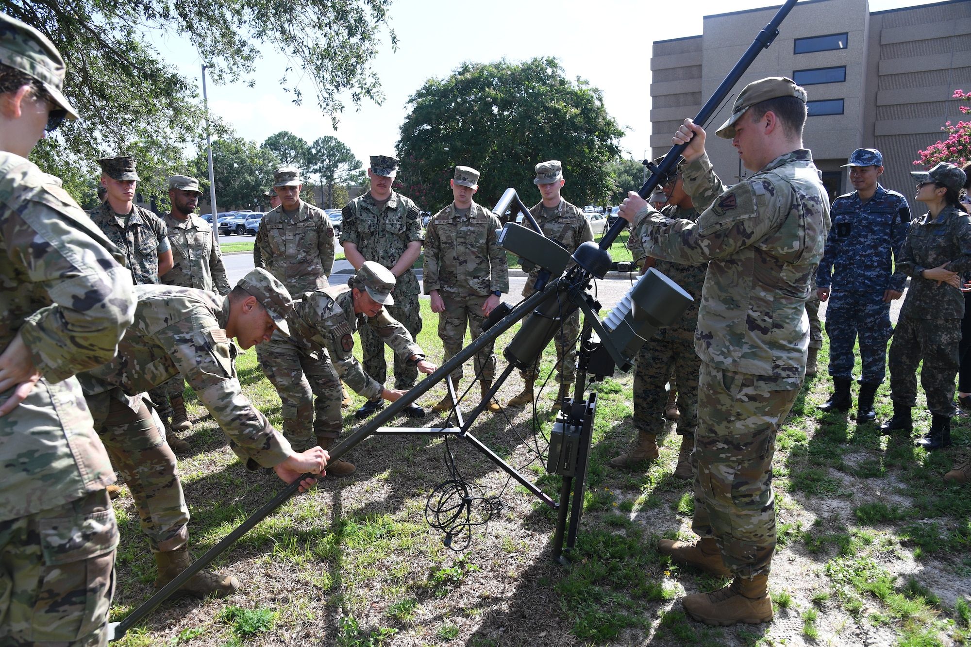 Airmen in the 335th Training Squadron assemble a TMQ-53 weather sensor during a training session outside of the Joint Weather Training Facility at Keesler Air Force Base, Mississippi, July 21, 2022. The weather apprentice course, which graduated 650 students this past year, takes 151 academic days to complete. Approximately 7,400 students go through the 335th TRS's 13 Air Force Specialty Codes each year. (U.S. Air Force photo by Kemberly Groue)