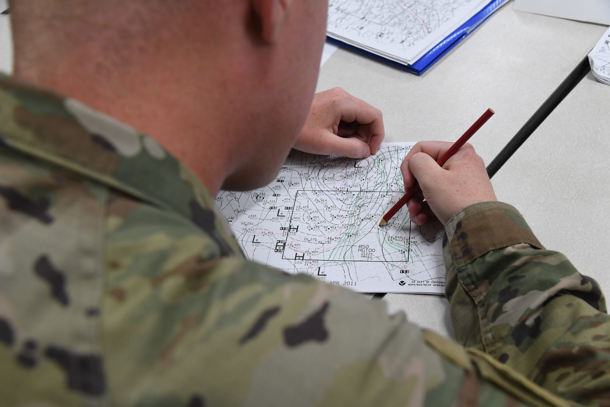 U.S. Air Force Airman 1st Class Christopher Scott, 335th Training Squadron student, plots a weather chart during the weather initial skills course inside of the Joint Weather Training Facility at Keesler Air Force Base, Mississippi, July 21, 2022. The weather apprentice course, which graduated 650 students this past year, takes 151 academic days to complete. Approximately 7,400 students go through the 335th TRS's 13 Air Force Specialty Codes each year. (U.S. Air Force photo by Kemberly Groue)