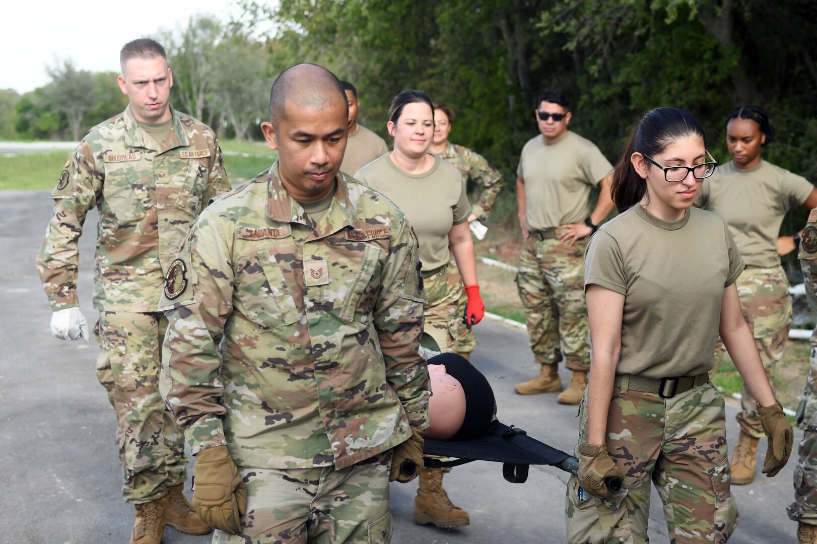 433rd Aeromedical Staging Squadron technicians, transport a synthetic patient on a litter during ground patient movement training at Joint Base San Antonio-Lackland, Texas, August 7, 2022. The exercise was the first for the unit since the start of the COVID-19 pandemic.  (U.S. Air Force photo by Tech. Sgt. Mike Lahrman)