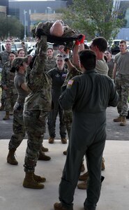 433rd Aeromedical Evacuation Squadron technicians lift a litter during a ground patient movement training exercise at Joint Base San Antonio-Lackland, Texas, August 7, 2022. The exercise was the first for the ASTS since the start of the COVID-19 pandemic and incorporated a C-124 Globemaster II aircraft static display to simulate loading into a C-130 Hercules aircraft. (U.S. Air Force photo by Tech. Sgt. Mike Lahrman)