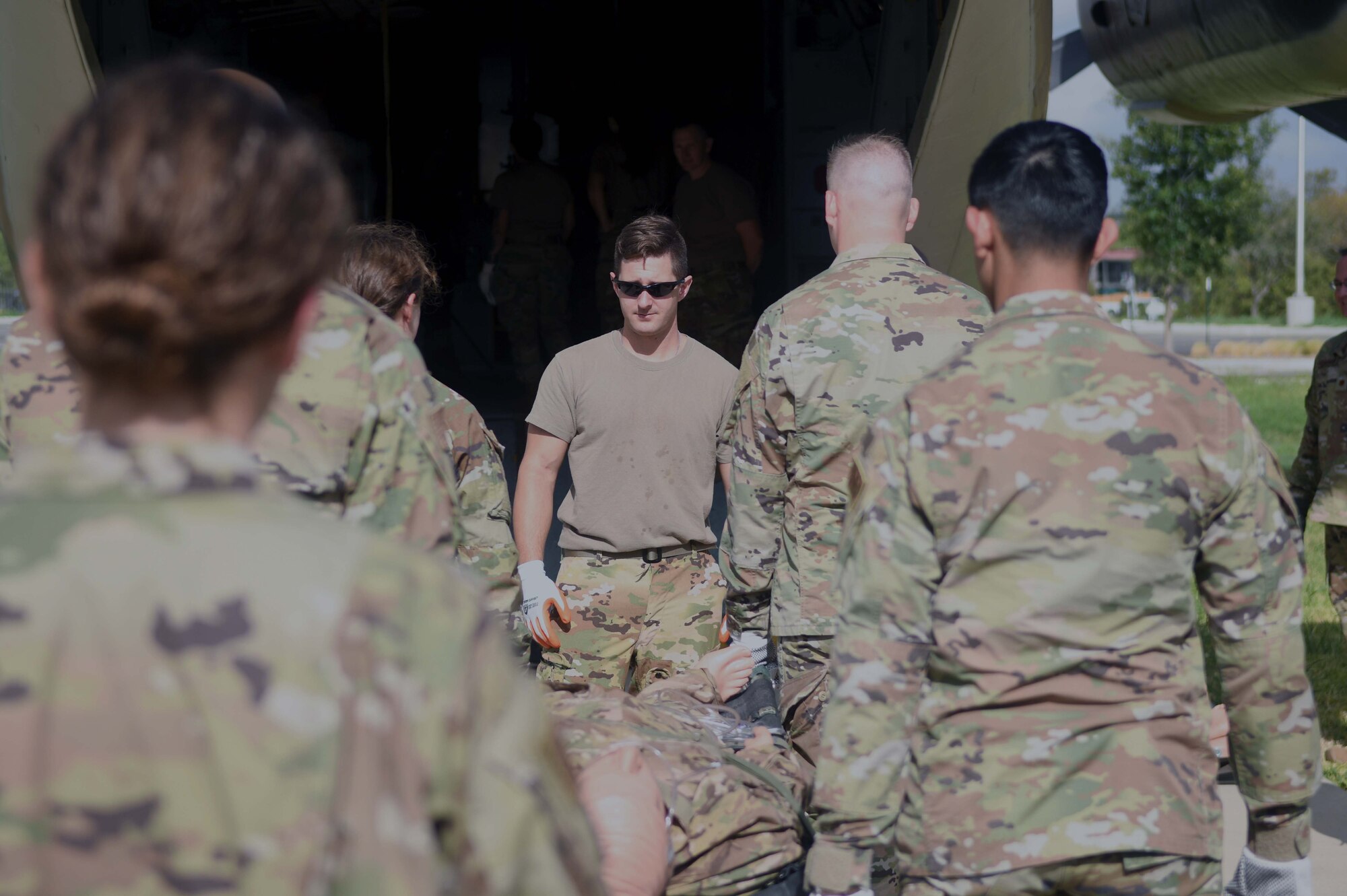 1st Lt. Ryan Schrader, 433rd Aeromedical Evacuation Squadron flight nurse, guides 433rd Aeromedical Staging Squadron personnel on lifting and transporting a simulated litter patient into a cargo aircraft during ground patient movement training at Joint Base San Antonio-Lackland, Texas, August 7, 2022. The exercise was the first for the 433rd ASTS since the start of the COVID-19 pandemic.  (U.S. Air Force photo by Tech. Sgt. Mike Lahrman)