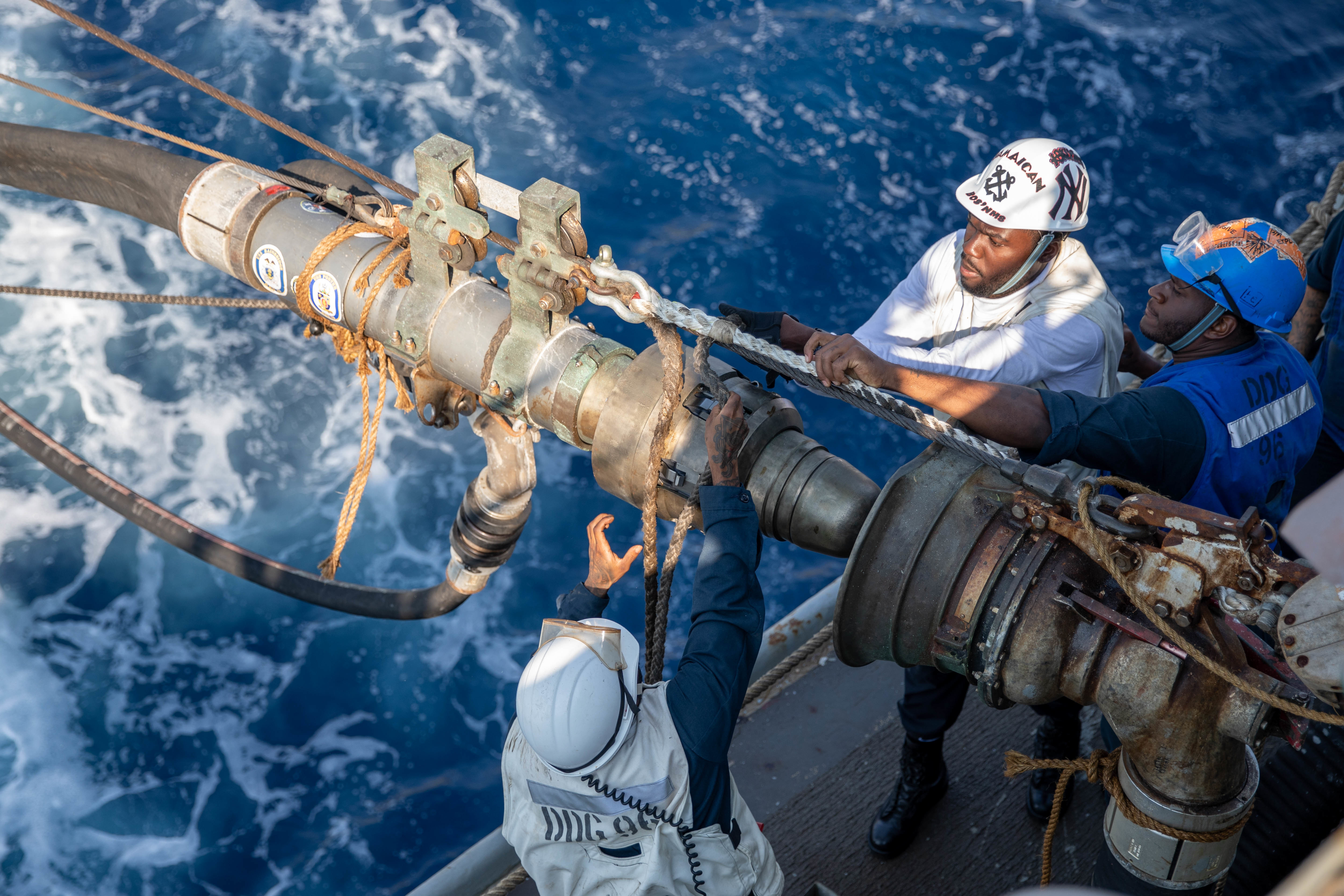 Sailors attach a short strap aboard USS Bainbridge (DDG 96) during a replenishment-at-sea with USNS Supply (T-AOE 6) in the Mediterranean Sea.
