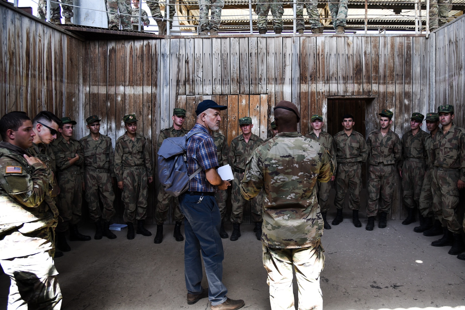 An advisor from Advisor Team 3320, assigned to the 3rd Security Force Assistance Brigade, exchanges information on room clearing best practices with U.S. National Guard Soldiers from Virginia and troops assigned to the Tajikistan Ministry of Defense during the military exercise “Regional Cooperation 22” Aug. 12, 2022, at a training site near Dushanbe, Tajikistan.