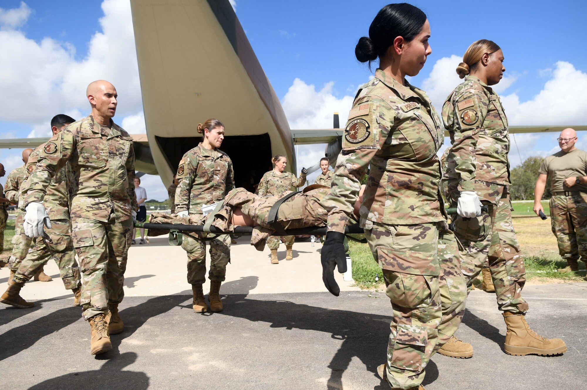 433rd Aeromedical Staging Squadron personnel transport a litter from a C-124 Globemaster II aircraft static display to an ambulatory vehicle during a ground patient movement training exercise at Joint Base San Antonio-Lackland, Texas, August 7, 2022. The use of the static display allowed participants to practice procedures in loading and offloading a C-130 Hercules aircraft during a medevac mission. (U.S. Air Force photo by Tech. Sgt. Mike Lahrman)