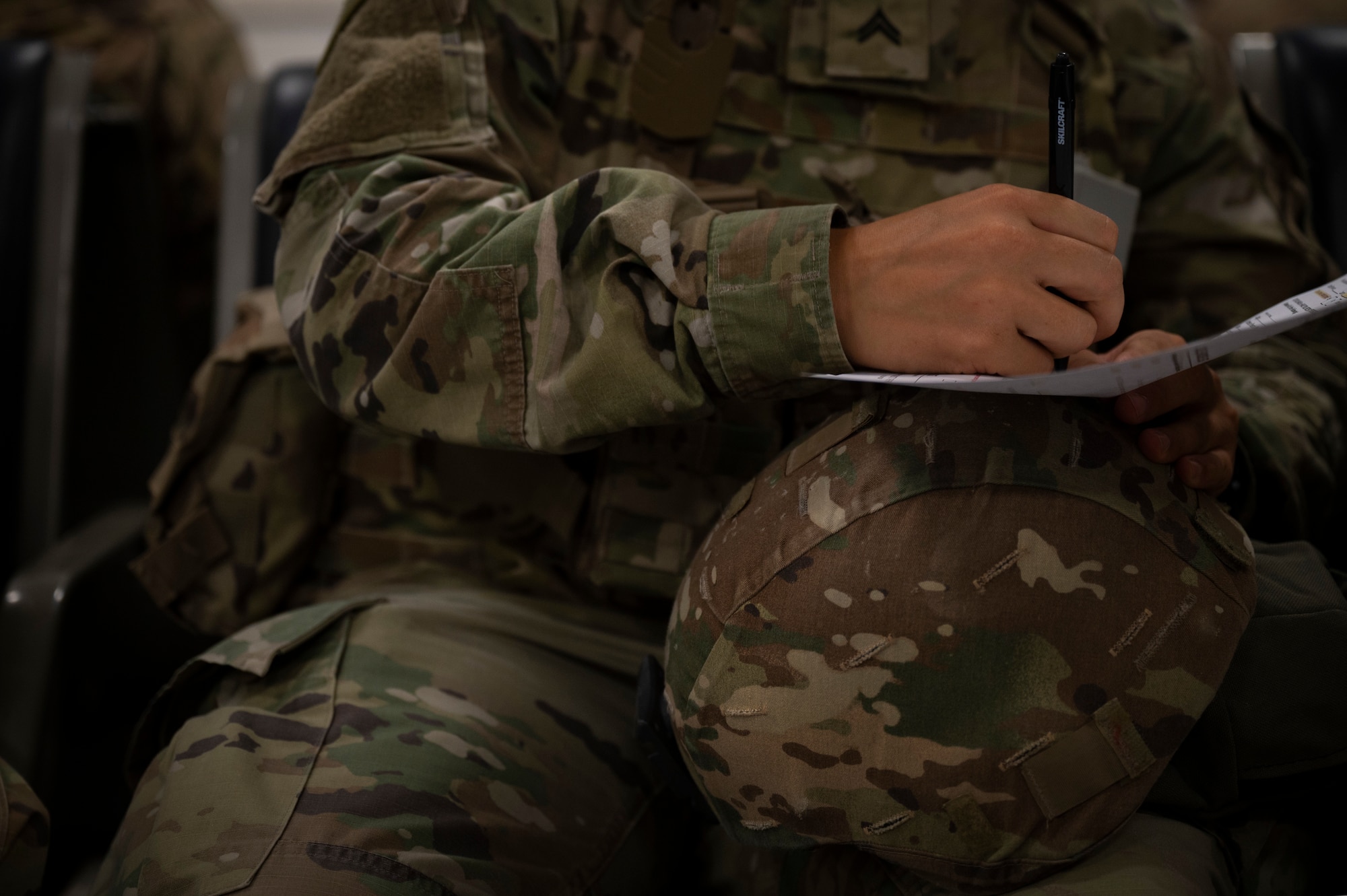 U.S. Army Cpl. Emily Belanger, 479th Chemical Battalion, 320th Chemical Company Chemical, Biological, Radiological and Nuclear specialist, fills out passenger processing paperwork during an Emergency Deployment Rapid Exercise at the 386th Expeditionary Logistics Readiness Squadron passenger terminal at Ali Al Salem Air Base, Kuwait, August 10, 2022. During an EDRE, the purpose is to rehearse a potential response to a real world scenario, such as deploying to another country for humanitarian relief with very little notice. (U.S. Air Force photo by Staff Sgt. Dalton Williams)