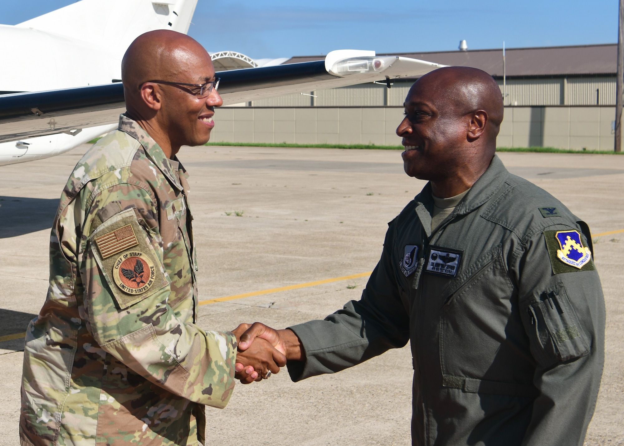 Two military members shake hands.
