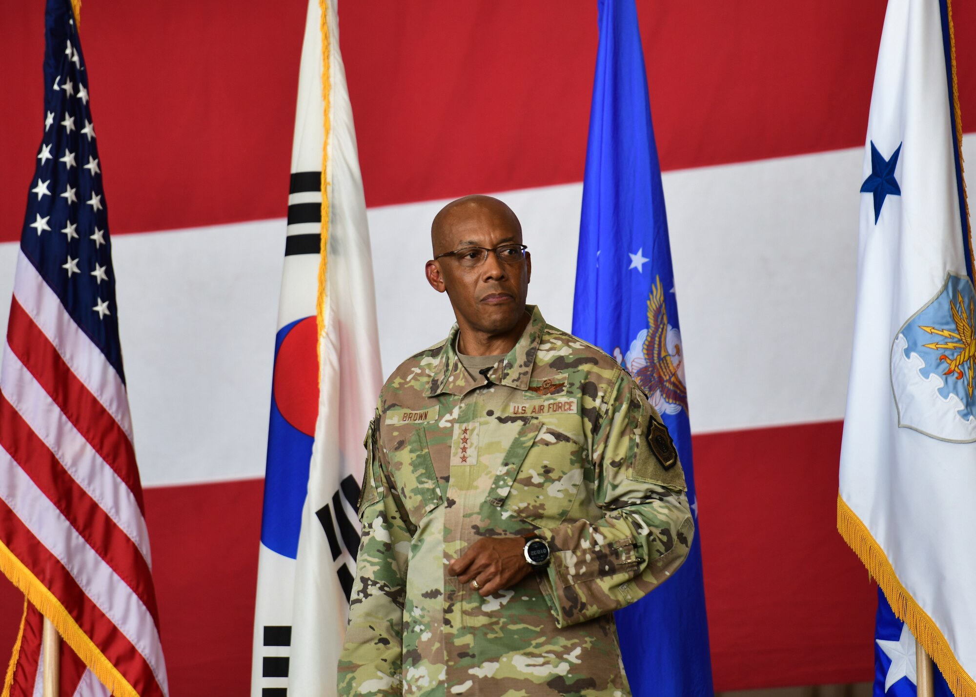 A military member stands on a stage.