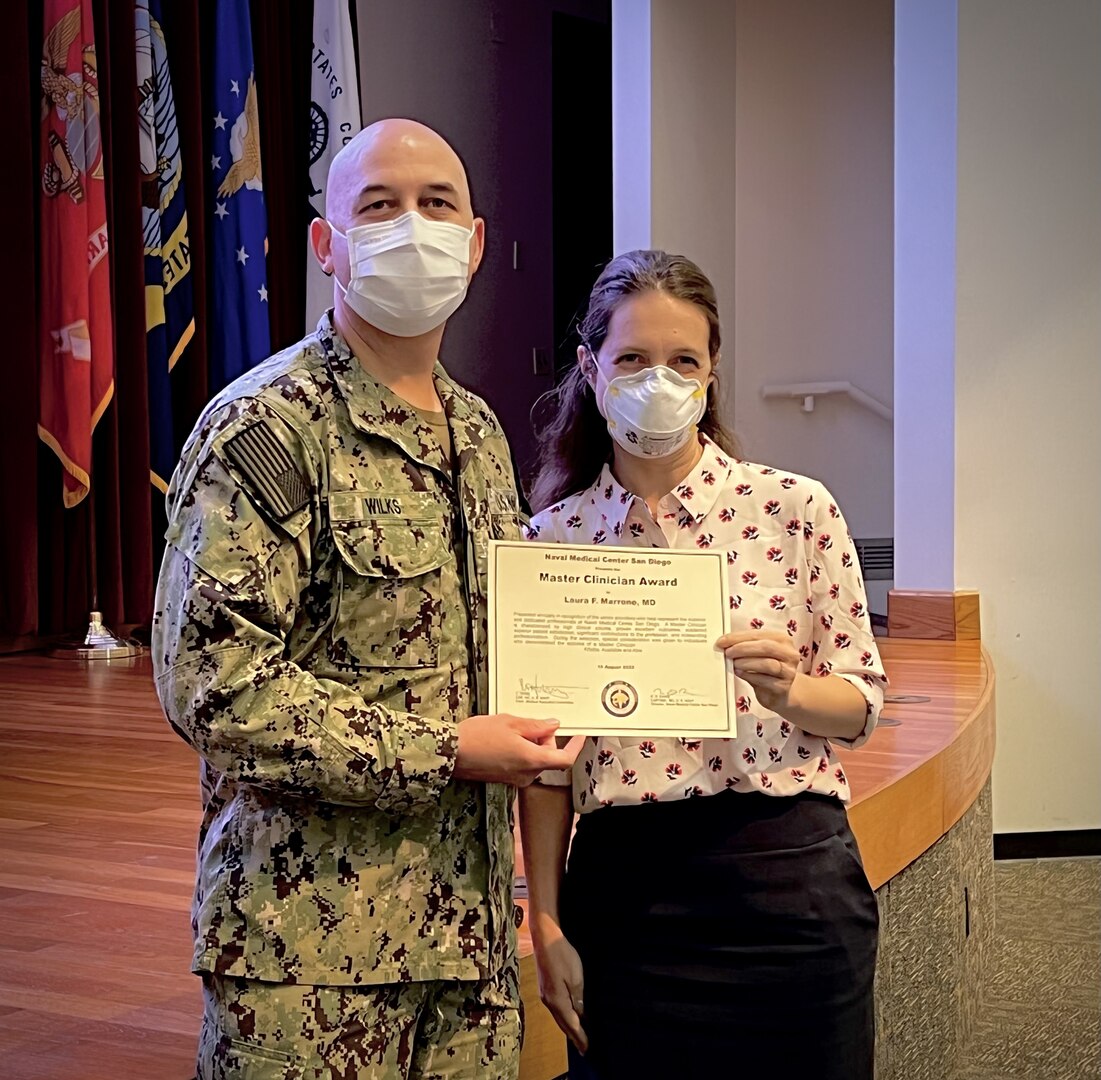 Capt. Timothy Wilks, Naval Medical Center San Diego (NMCSD) executive officer, presents the Master Clinician Award to Dr. Laura Marrone during a ceremony at NMCSD's auditorium on Aug. 10. During the ceremony, 24 senior clinicians received the Master Clinician Award and 39 other clinicians were recognized as Associate Master