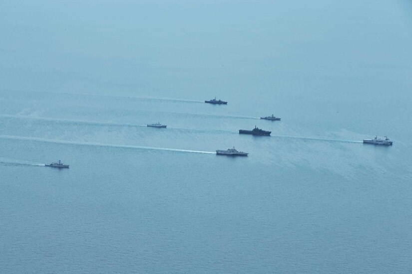 U.S., Indonesia and Singapore naval ships sail in formation as seen from above.