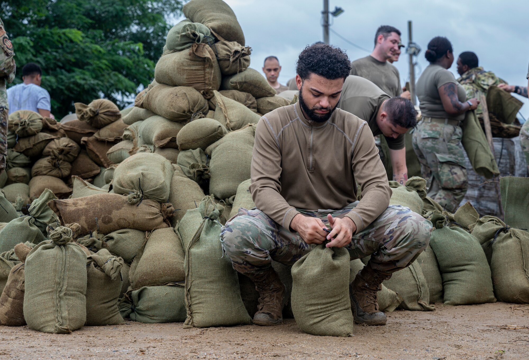 Senior Airman Bryant Lewis, 51st Operation Support Squadron air traffic controller, ties a sand bag at Osan Air Base, Republic of Korea, Aug. 9, 2022.