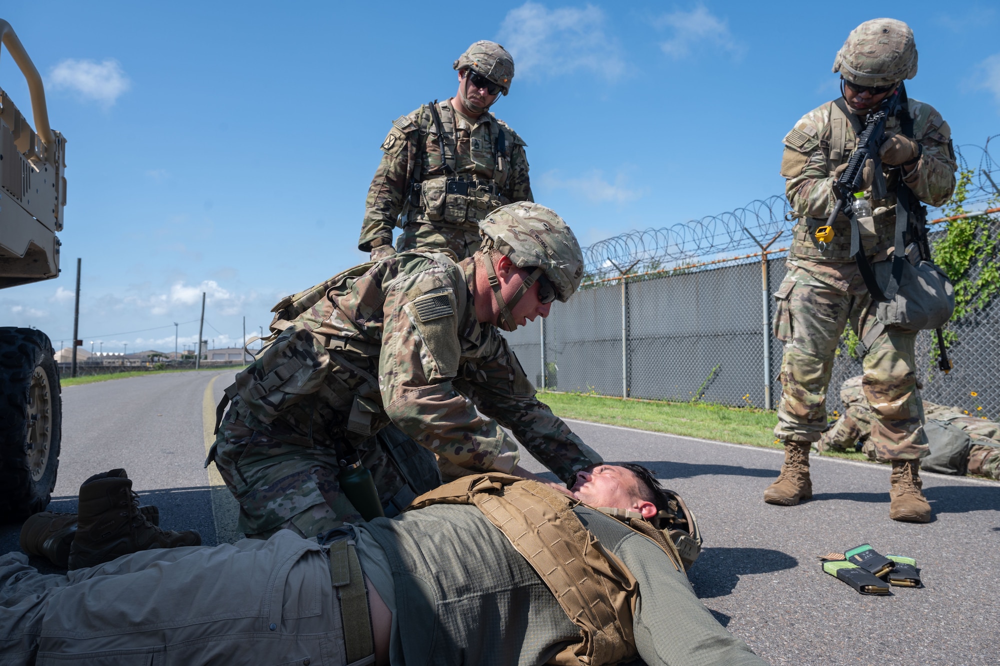 An Army Soldier applies first aid to an Air Force Airman in a simulated scenario.