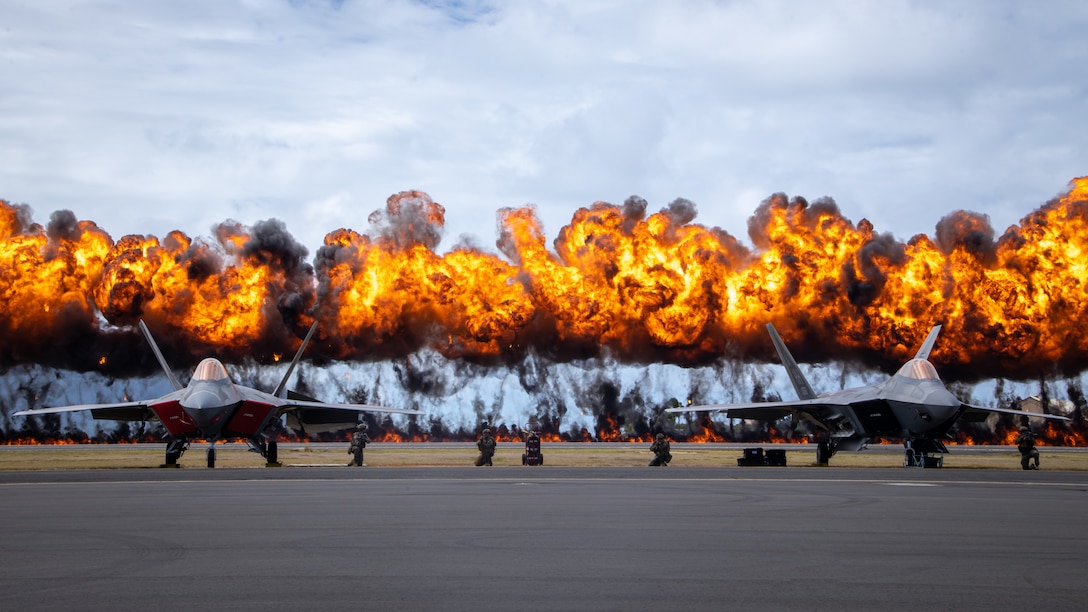 The “Wall of Fire” explodes behind two U.S. Air Force F-22 Raptors during the Joint Air-Ground Task Force Demonstration as part of the 2022 Kaneohe Bay Air Show, Marine Corps Air Station Kaneohe Bay, Marine Corps Base Hawaii, Aug. 13, 2022. The air show provided an opportunity to demonstrate the capabilities of a Joint Force in the Indo-Pacific Region. The Kaneohe Bay Air Show, which contained aerial performances, static displays, demonstrations and vendors, was designed to express MCBH’s appreciation to the residents of Hawaii and their continued support of the installation.