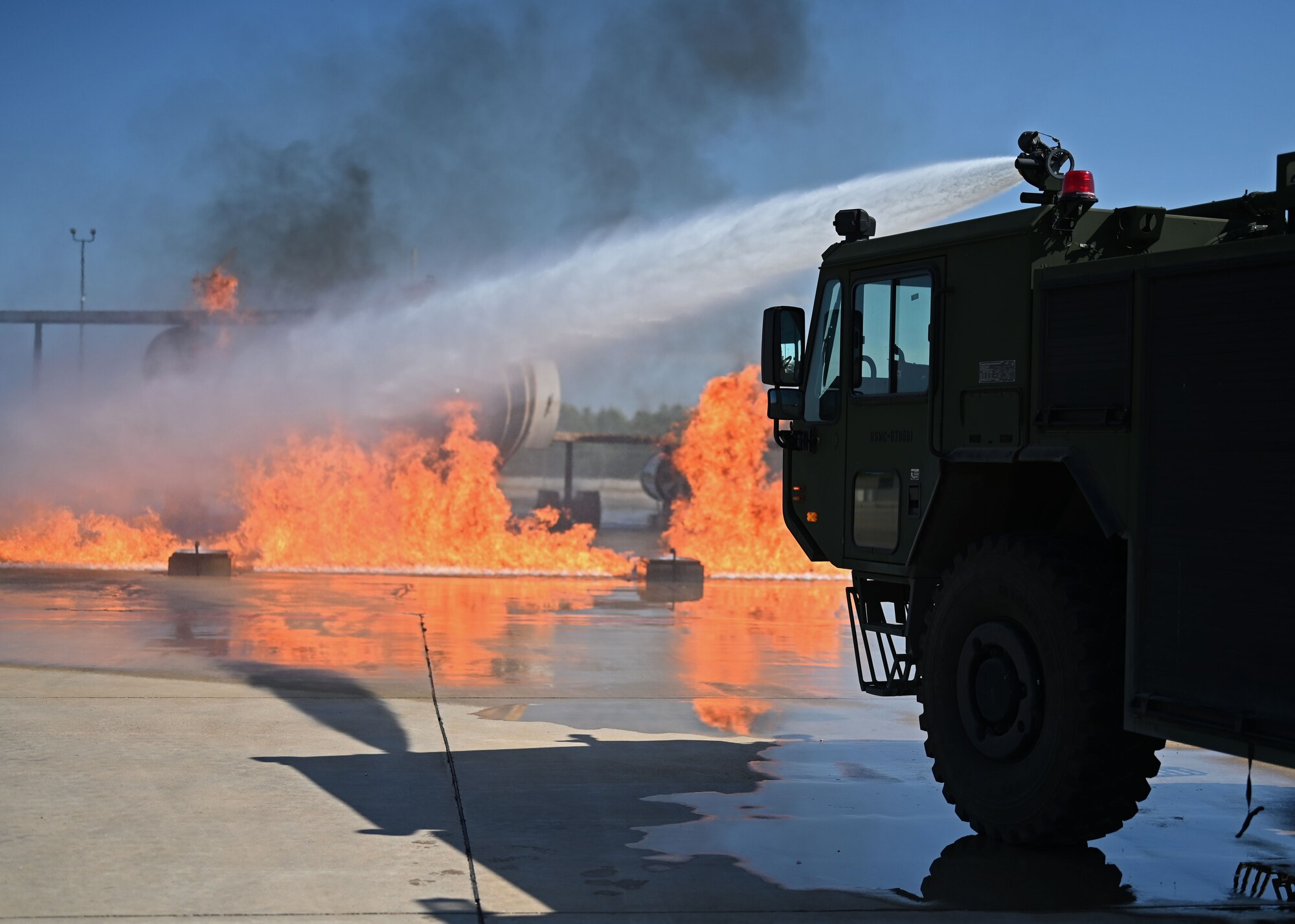 U.S. Air Force Lt. Gen. Brian S. Robinson, commander of Air Education and Training Command, and his wife, Mrs. Maureen Robinson, put out an aircraft fire from inside a fire truck during a visit to the Louis F. Garland Department of Defense Fire Academy, Goodfellow Air Force Base, Texas, Aug. 11, 2022. The fire academy is responsible for training all DoD firefighters, whose graduates are stationed at military installations all over the world. (U.S. Air Force photo by Senior Airman Ethan Sherwood)