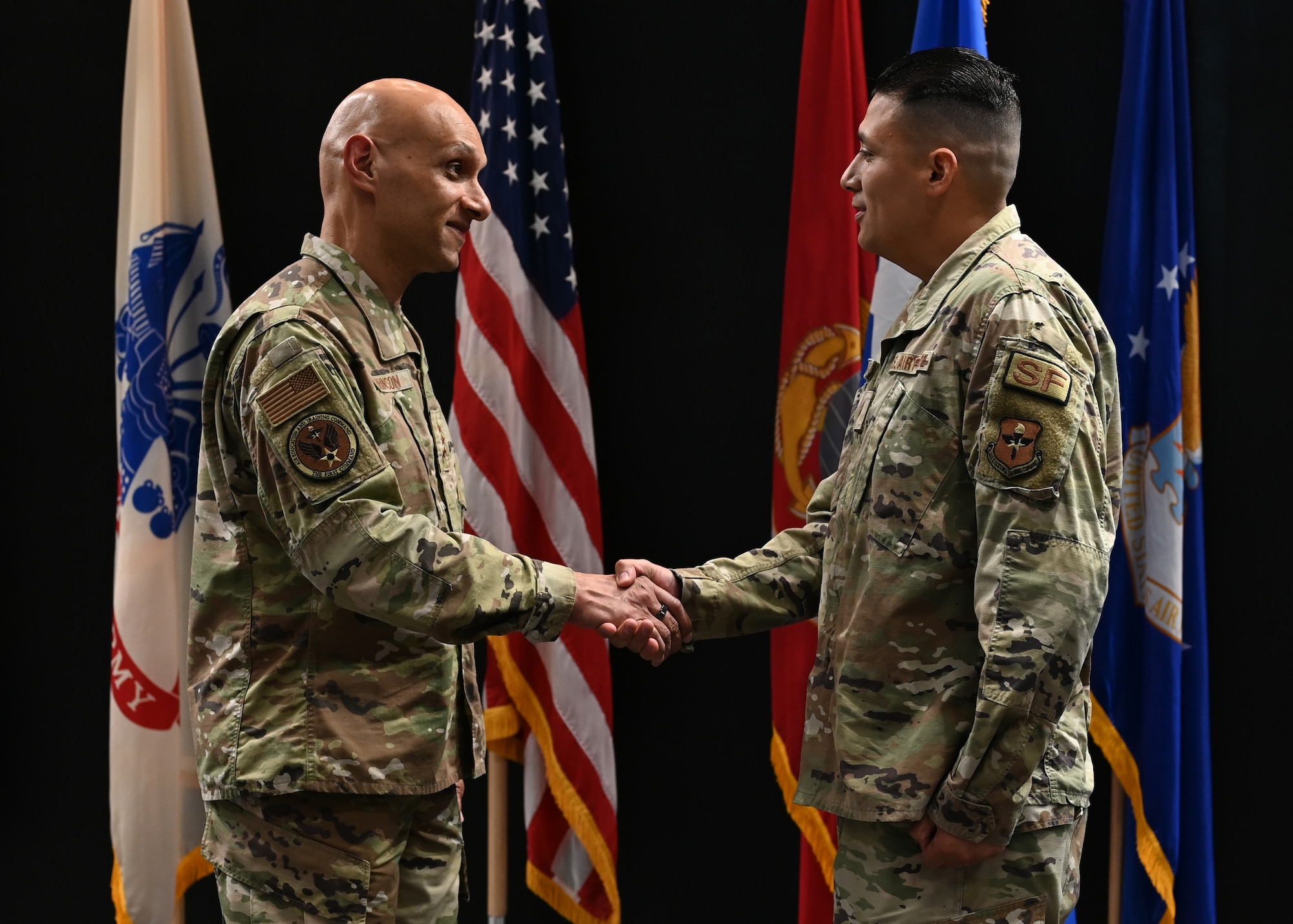 U.S. Air Force Lt. Gen. Brian S. Robinson, commander of Air Education and Training Command, coins Tech. Sgt. Julian Rangel, defender with the 17th Security Forces Squadron, for his outstanding performance at Goodfellow Air Force Base, Texas, August 11, 2022. Robinson recognized several Airmen for their efforts during his visit. (U.S. Air Force photo by Senior Airman Ethan Sherwood)