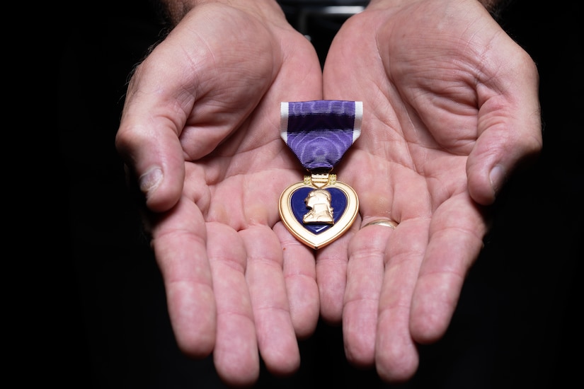 Retired Command Sgt. Maj. James K. Bodecker displays the Purple Heart he was awarded March 20, 2006, after being shot by a sniper in Ramadi, Iraq, February 17, 2006.