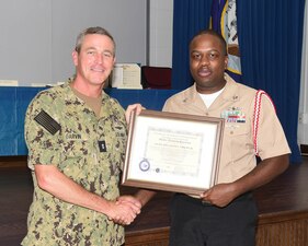 MERIDIAN, Miss. (Aug. 11, 2022) Rear Adm. Pete Garvin, commander, Naval Education and Training Command (NETC), left, presents the Master Training Specialist (MTS) certificate to Logistics Specialist 1st Class Calvin F. Wright Jr during a Naval Technical Training Center (NTTC) Meridian all-hands call at Naval Air Station Meridian, Mississippi, Aug. 11, 2022.  NETC’s MTS Program is a voluntary program designed to develop and qualify those individuals who possess advanced knowledge, skills and abilities that will enhance the delivery of quality education and training in the Navy. NTTC Meridian provides entry-level “A” school training to students in administration and supply ratings, as well as extensive training to top-performing naval personnel in the yeoman rating to qualify as flag writers. (U.S. Navy photo by Penny Randall)