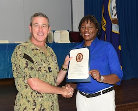 MERIDIAN, Miss. (Aug. 11, 2022) Rear Adm. Pete Garvin, commander, Naval Education and Training Command, left, presents Yvette Neal, with a certificate recognizing her 15 years of federal service during a Naval Technical Training Center (NTTC) Meridian all-hands call at Naval Air Station Meridian, Mississippi, Aug. 11, 2022. NTTC Meridian provides entry-level “A” school training to students in administration and supply ratings, as well as extensive training to top-performing naval personnel in the yeoman rating to qualify as flag writers. (U.S. Navy photo by Penny Randall)