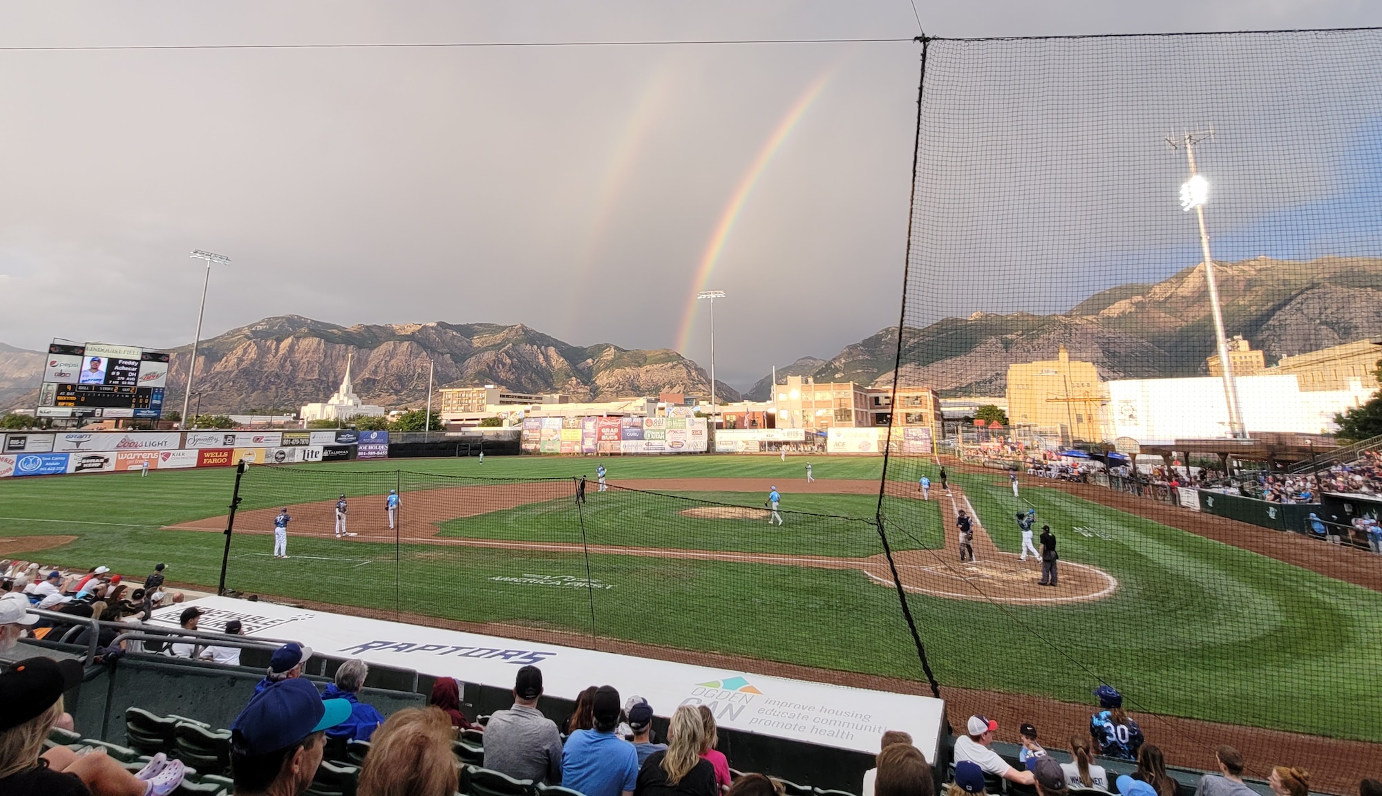 A rainbow appears over Lindquist Field during a baseball game.