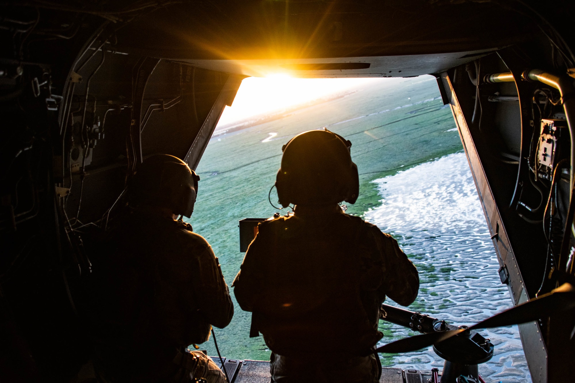 two people look at sunset out of back of aircraft
