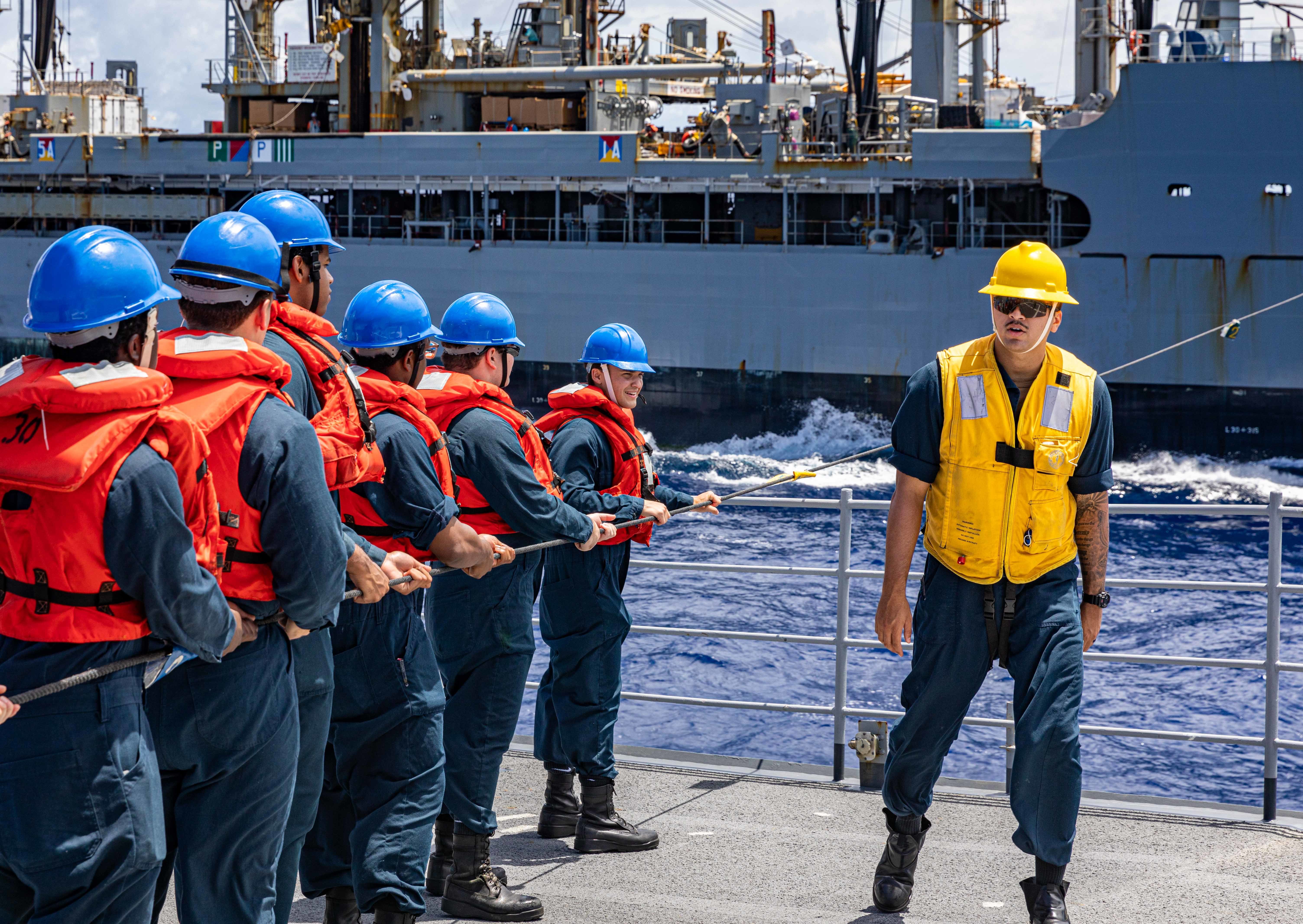 Sailors on the foc’s’le of Ticonderoga-class guided-missile cruiser USS Chancellorsville (CG 62) heave the phone and distance line while conducting a replenishment-at-sea with USNS Rappahannock (T-AO-204) in the Philippine Sea on Aug. 12, 2022.