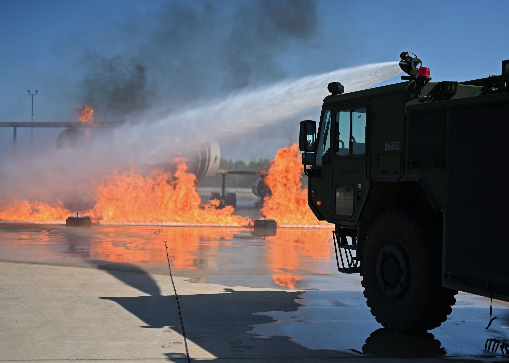 U.S. Air Force Lt. Gen. Brian S. Robinson, commander of Air Education and Training Command, and his wife, Mrs. Maureen Robinson, put out an aircraft fire from inside a fire truck during a visit to the Louis F. Garland Department of Defense Fire Academy, Goodfellow Air Force Base, Texas, Aug. 11, 2022. The fire academy is responsible for training all DoD firefighters, whose graduates are stationed at military installations all over the world. (U.S. Air Force photo by Senior Airman Ethan Sherwood)