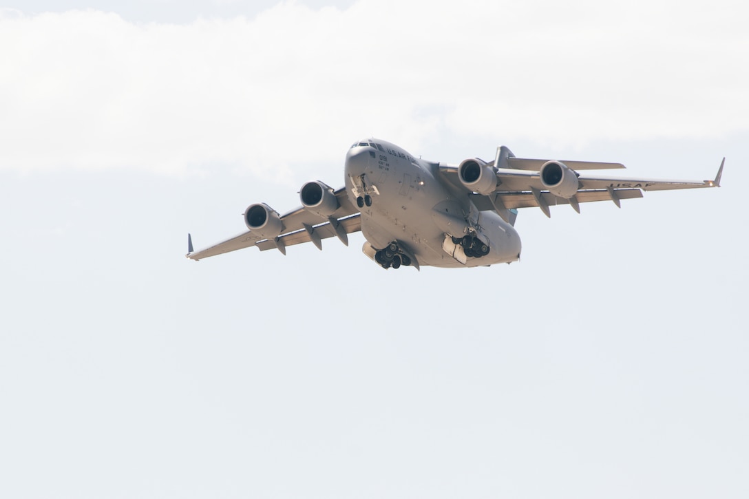A U.S. Air Force C-17 Globemaster III aircraft with 3rd Airlift Squadron, 436th Airlift Wing, carrying a Marine Corps AH-1Z Viper helicopter with Marine Light Attack Helicopter Squadron (HMLA) 267, Marine Aircraft Group 39, 3rd Marine Aircraft Wing, prepares to land during joint exercise Patriot Hook at Marine Corps Air Ground Combat Center, Twentynine Palms, California, June 29, 2022. Air Force 60th Air Mobility Wing delivered Marine Corps UH-1Y Venom helicopters and AH-1Z Viper helicopters to conduct strike missions, testing HMLA-267 rapid deployment capabilities. (U.S. Marine Corps photo by Lance Cpl. Andrew Bray)