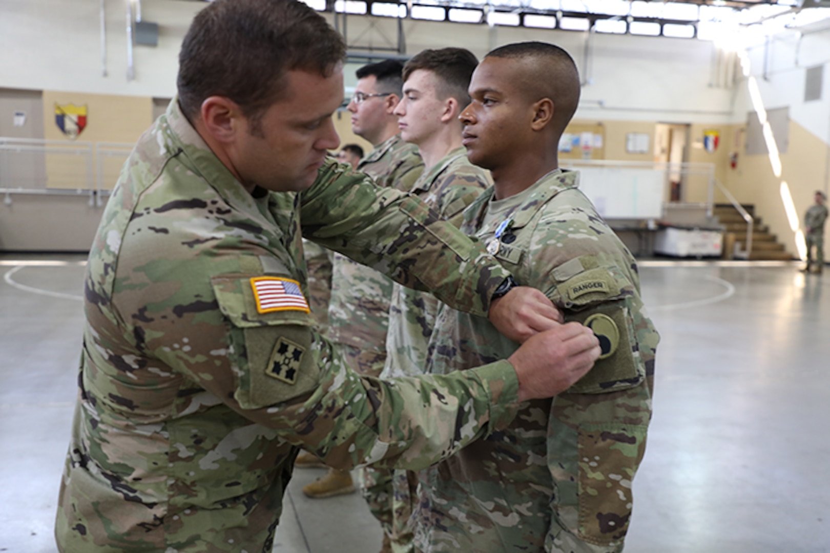 Pfc. Tristian Hines, of Somerset, Ky., who will be joining the 1-149th Infantry, gets his unit patch from Sgt. 1st Class Anthony Williamson, readiness NCO of the 1st Battalion, 149th Infantry Brigade during First Formation July 21, 2022.