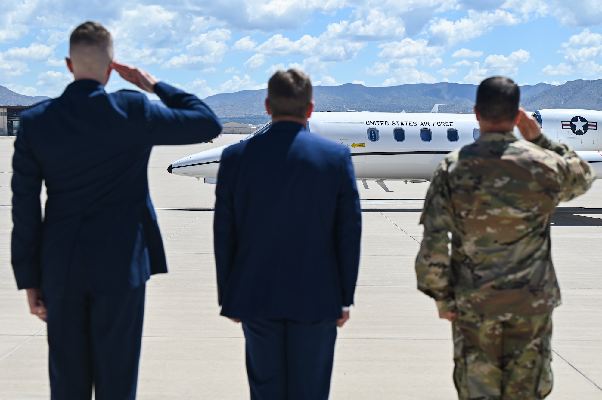 Men salute plane.