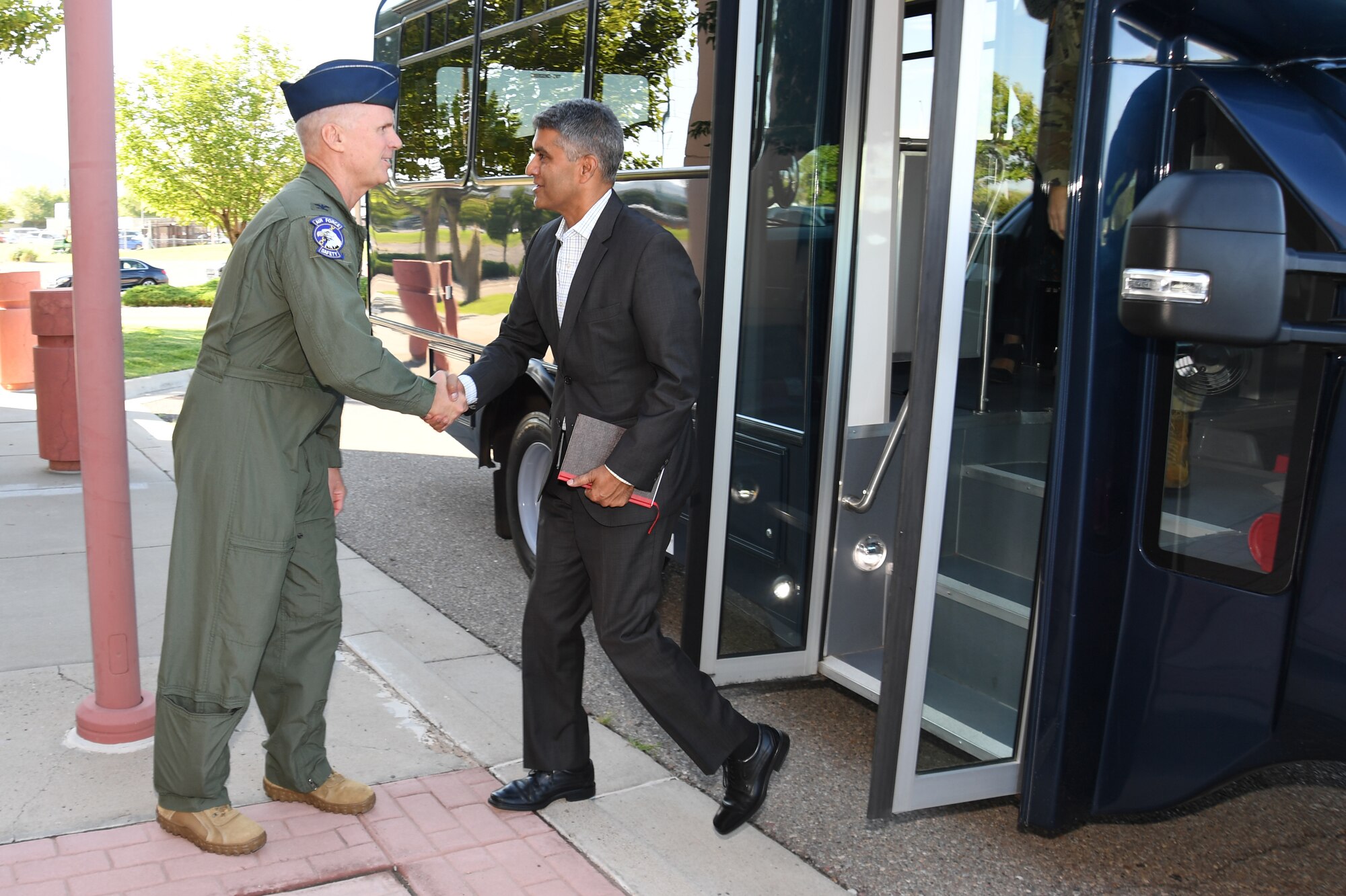 Military and civilian personnel walking into building