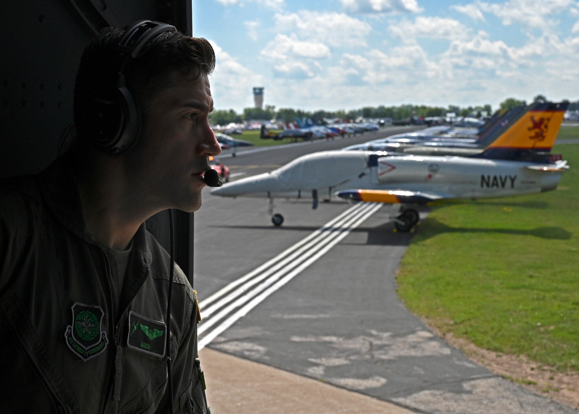 U.S. Air Force Tech. Sgt. Jorge Garcia-Hernandez, loadmaster with the 7th Airlift Squadron, looks out the side door of a C-17 Globemaster III upon landing at the Experimental Aircraft Association Airventure Air Show, Oshkosh, Wis., July 27, 2022. EAA is the largest annual air show in the U.S. and coined as The World’s Greatest Aviation celebration. (U.S. Air Force photo by Senior Callie Norton)