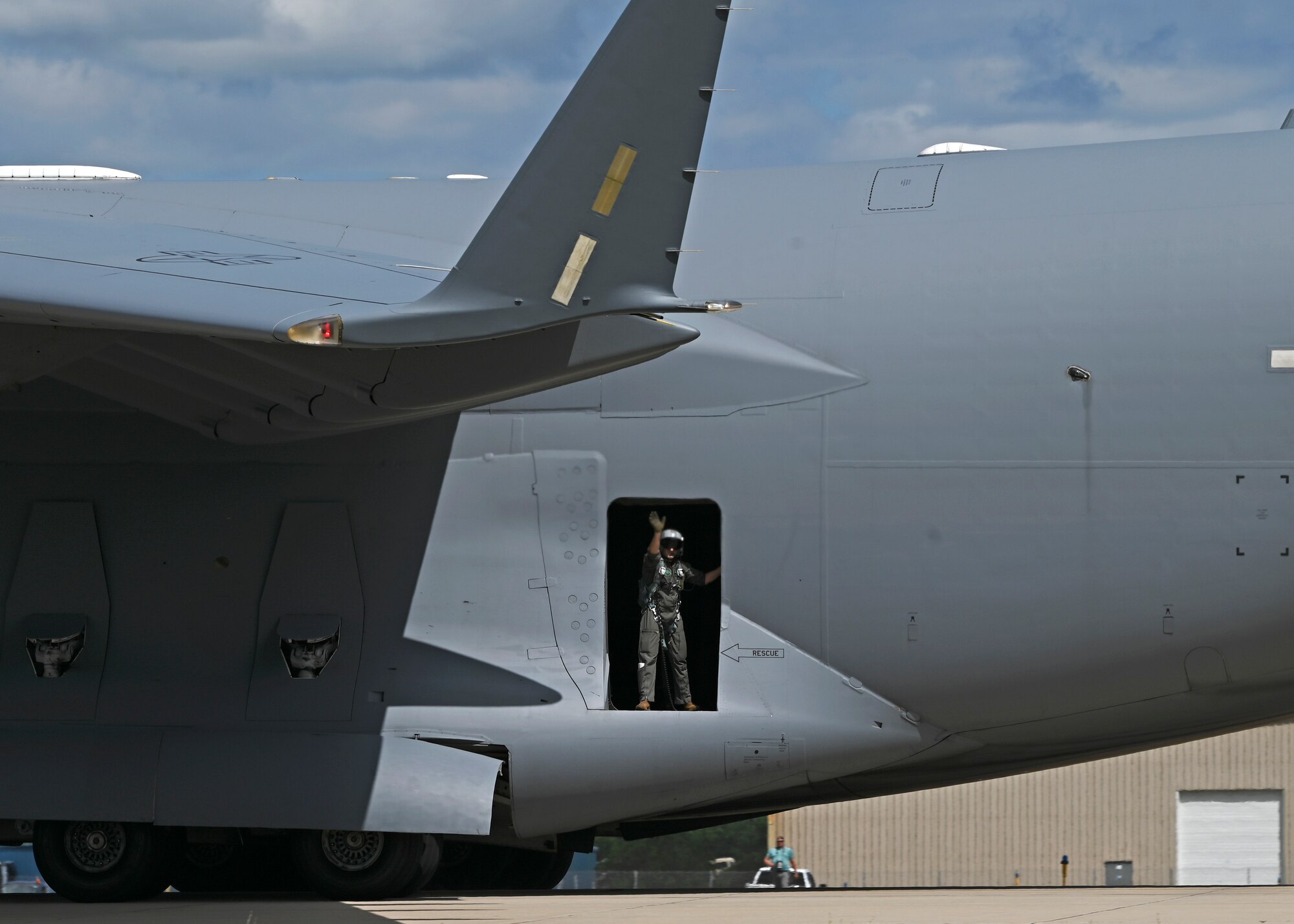 U.S. Air Force Tech. Sgt. Jorge Garcia-Hernandez, loadmaster with the 7th Airlift Squadron, waves out the side door of a C-17 Globemaster III upon landing after the C-17 West Coast Demonstration Teams demo at the Experimental Aircraft Association Airventure Air Show, Oshkosh, Wis., July 27, 2022. EAA is the largest annual air show in the U.S. and coined as The World’s Greatest Aviation celebration. (U.S. Air Force photo by Senior Callie Norton)