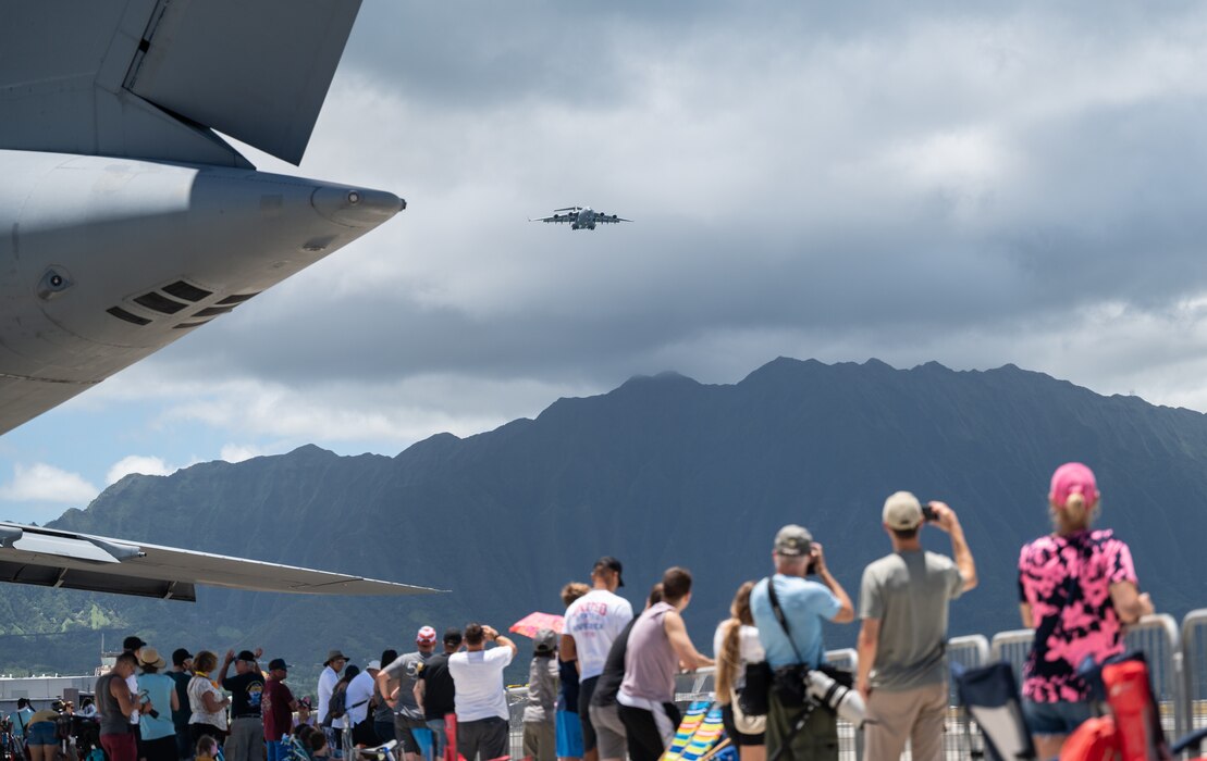 Spectators view a flight demonstration from a C-17 Globemaster III assigned to the 535th Airlift Squadron during the Kaneohe Bay Air Show at Marine Corps Base Hawaii, Hawaii, Aug. 12, 2022. The airshow was held to show MCBH’s appreciation for the local community’s support and to continue fostering positive relations. (U.S. Air Force photo by Staff Sgt. Alan Ricker)