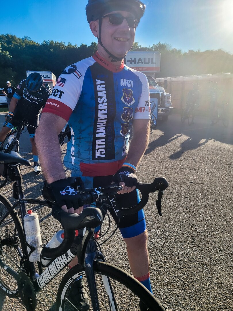 Cyclist walking while holding his bike