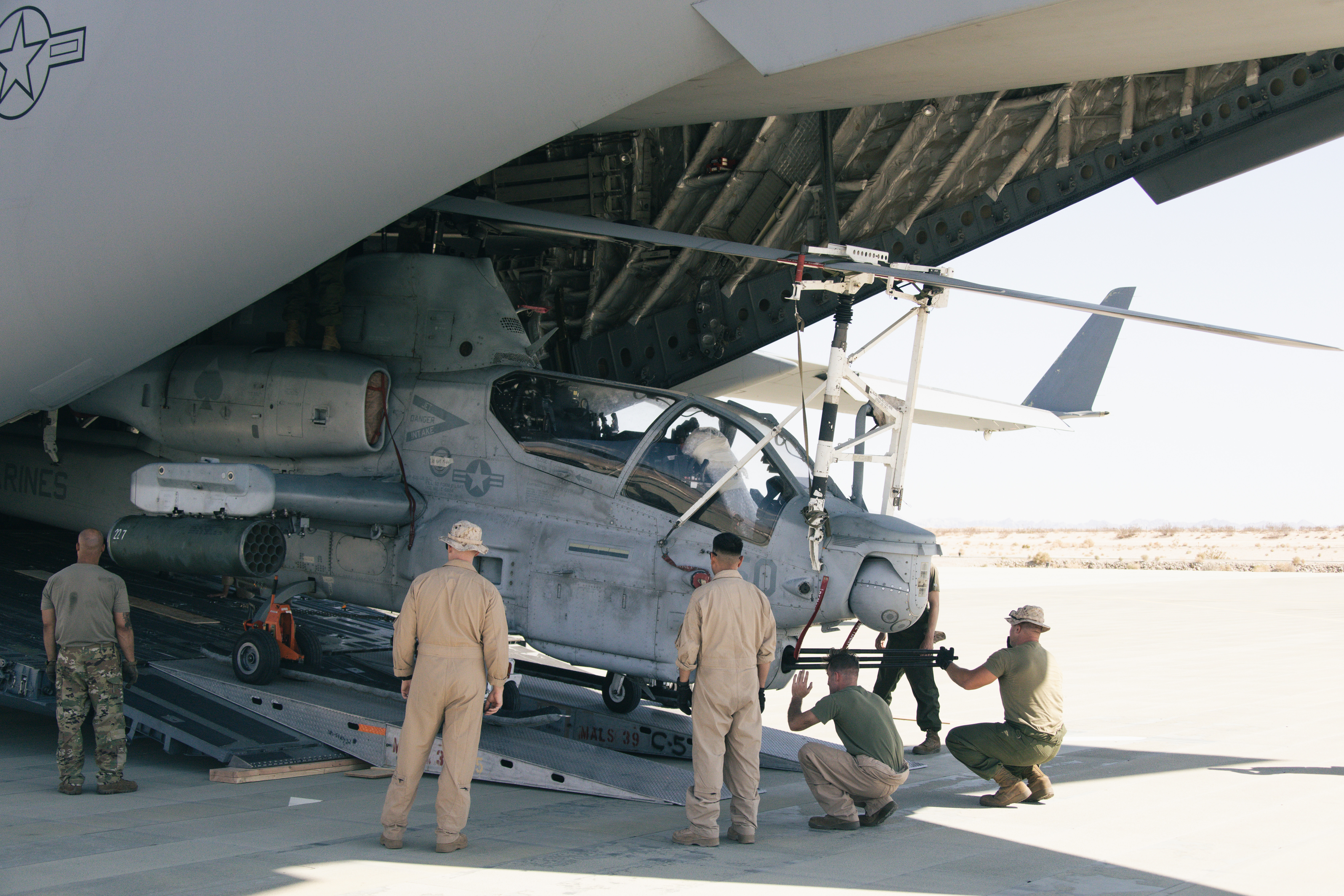 U.S. Marines and U.S. Airmen unload an AH-1Z Viper helicopter from a C-17 Globemaster III
