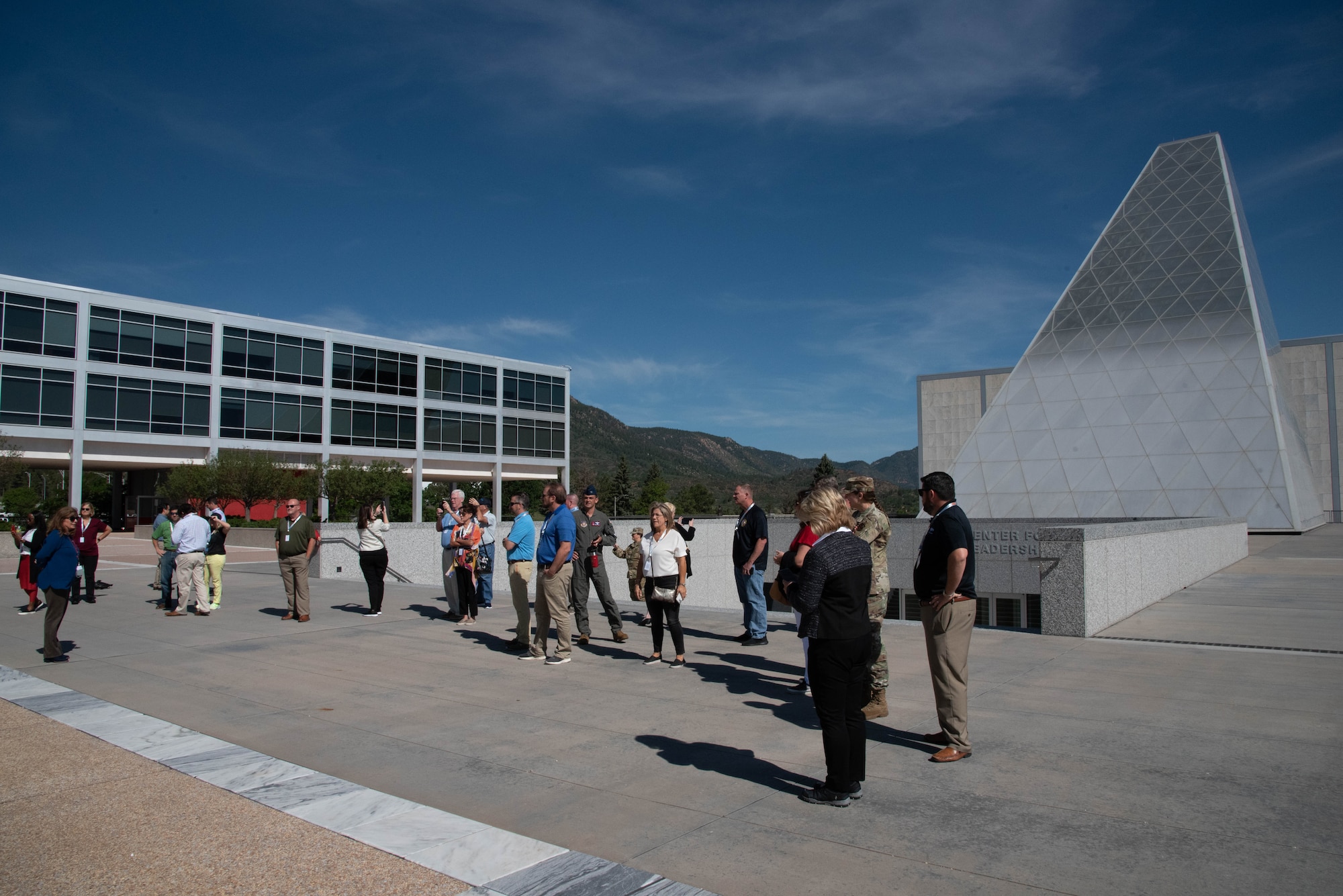 A group of people stand in an open, outdoor space.