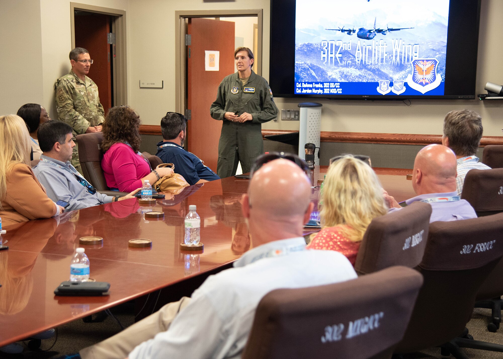 People sit at a table as Col. Franks stands at the front talking