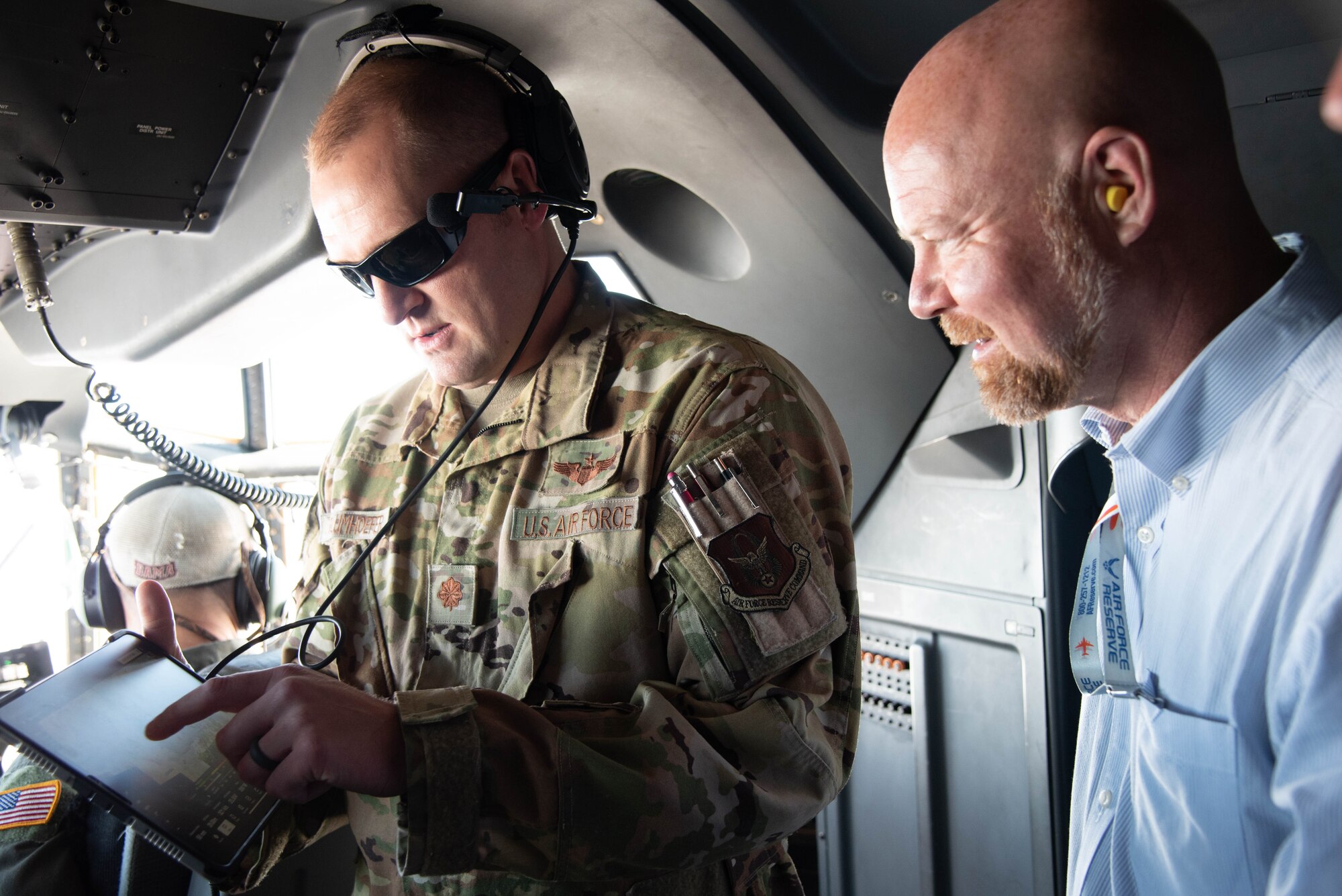 A pilot shows someone an iPad with a map pulled up