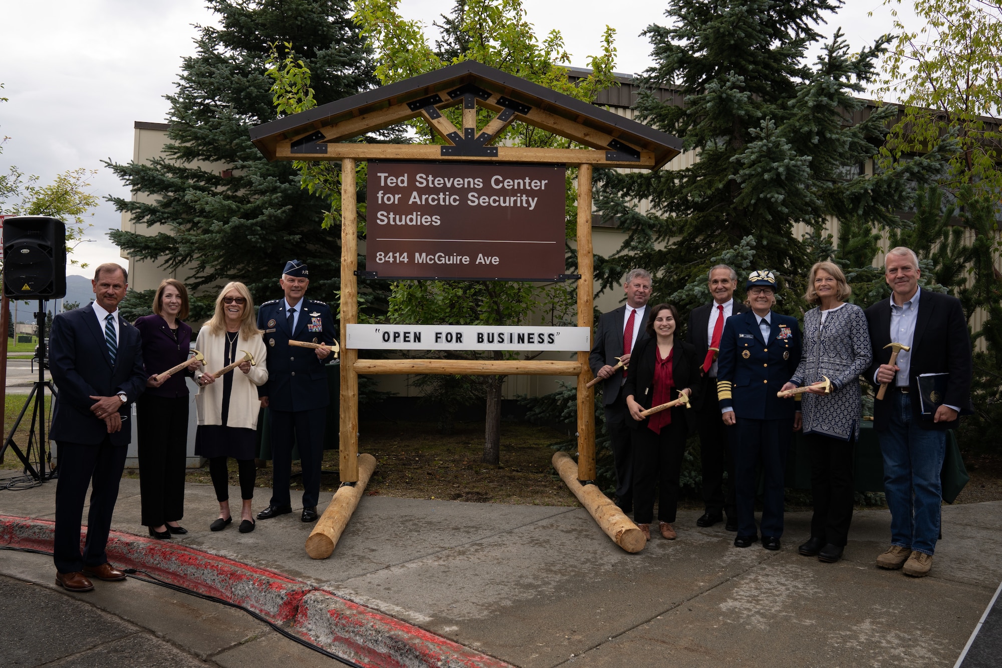 A photo of a group posing in front of a sign