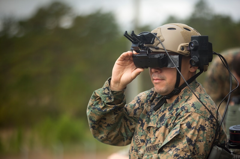 A Marine looks through a virtual reality headset.
