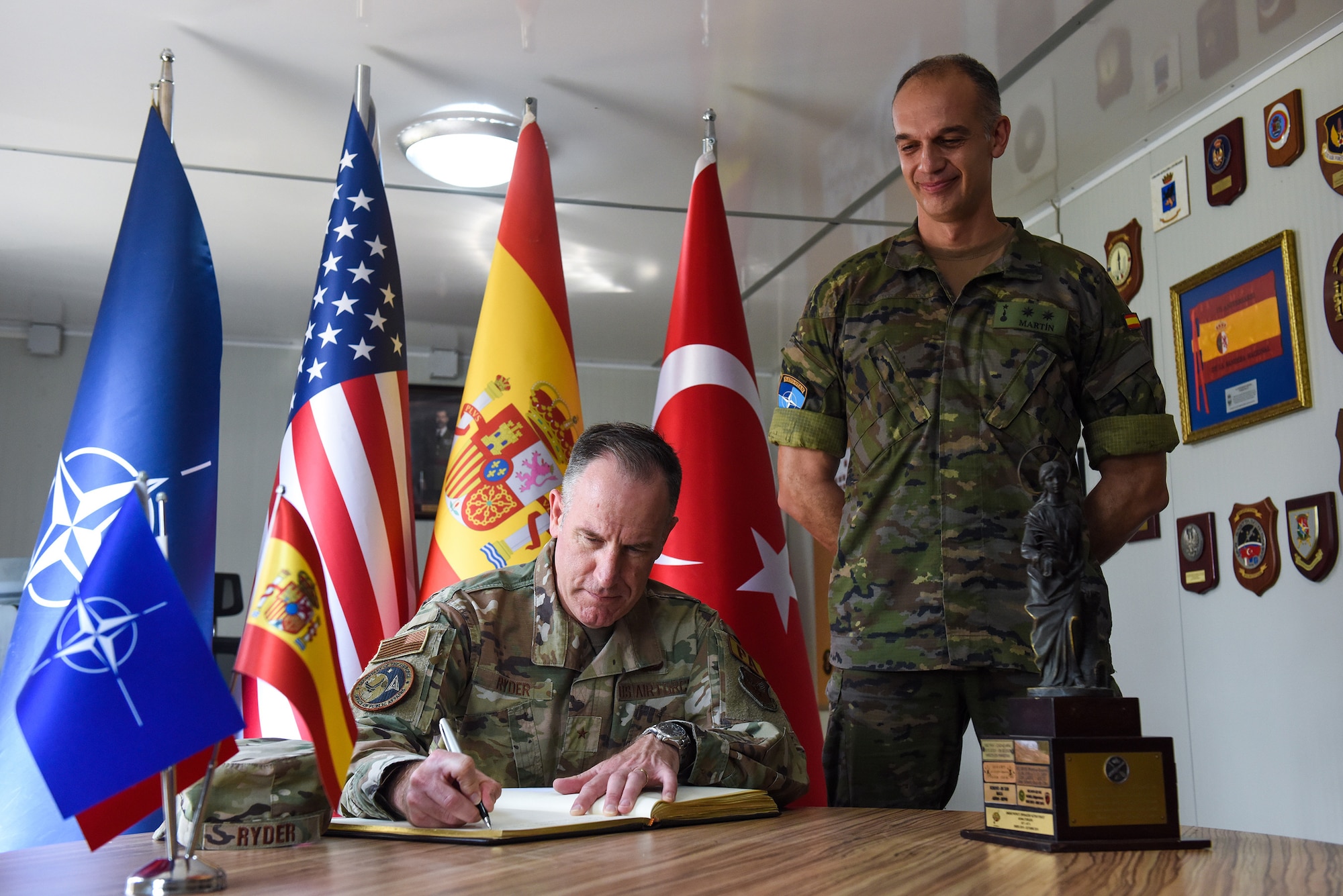 Spanish Army Lt. Col. Sergio Martín Gallego (right), Spanish Patriot Unit commander, looks down as U.S. Brig. Gen. Patrick Ryder, Office of the Secretary of the Air Force director of public affairs, writes a message in the Spanish Battery Compound’s guest book during a visit to Incirlik Air Base, Turkey, Aug. 4, 2022.