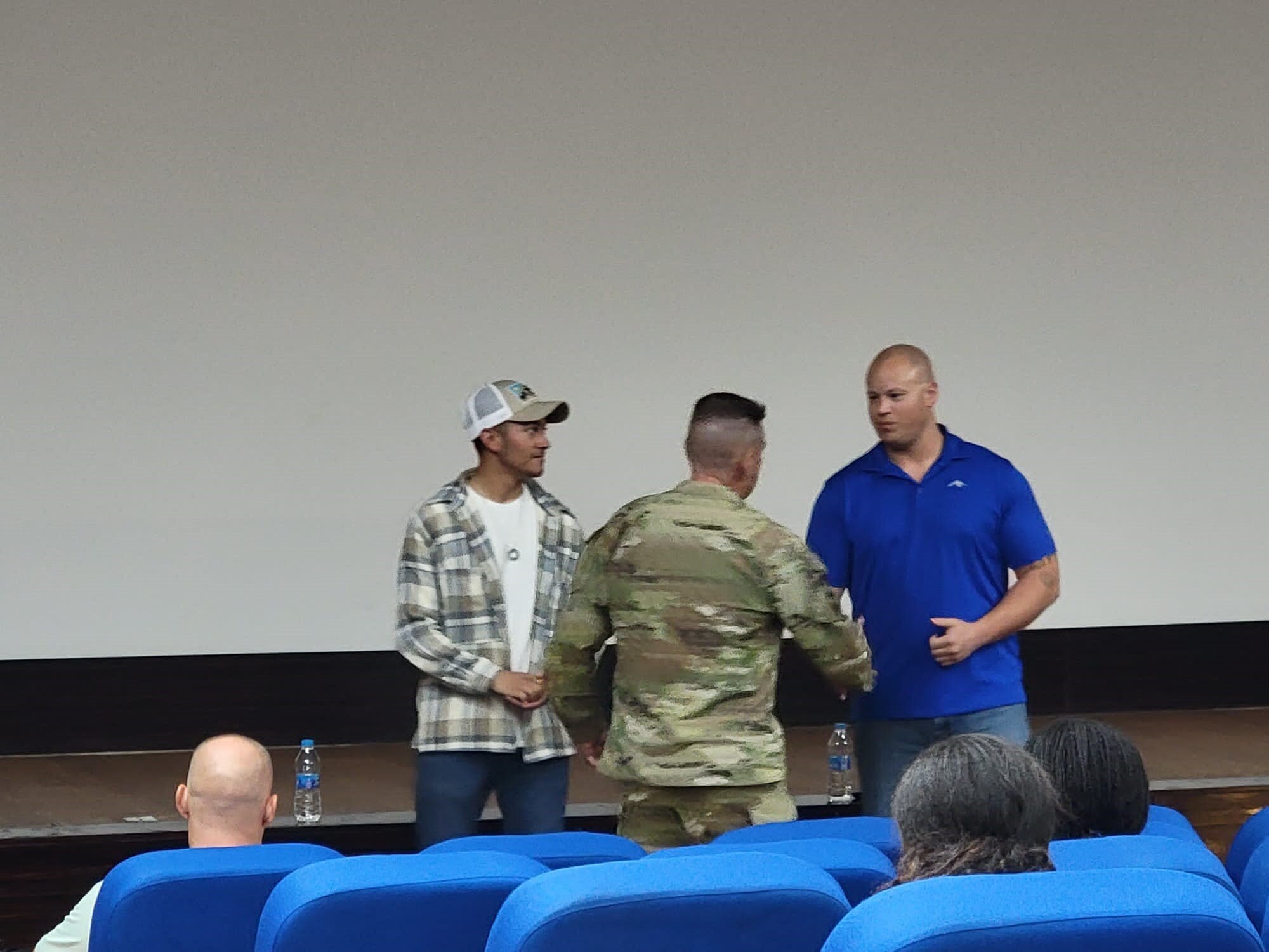 U.S. Air Force Staff Sgt. Kory Talbert accepts a challenge coin at an undisclosed location, July 23, 2022. He was coined in recognition of his contributions to the DOD Men's SAPR campaign, which trained and educated attendees to help male survivors of sexual assault. (Courtesy Asset)