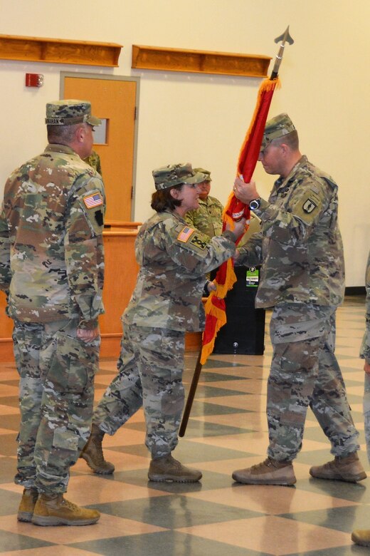 Brig. Gen. Laura McHugh (center), deputy adjutant general-Army, Pennsylvania National Guard, passes the 166th Regiment Regional Training Institute colors to incoming commander Col. Robert Jorgensen Jr. during a change-of-command ceremony on Aug. 12, 2022, at Fort Indiantown Gap, Pa. At left is outgoing commander Col. Patrick Monahan. (Pennsylvania National Guard photo by Brad Rhen)