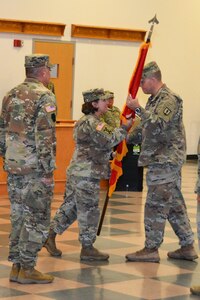 Brig. Gen. Laura McHugh (center), deputy adjutant general-Army, Pennsylvania National Guard, passes the 166th Regiment Regional Training Institute colors to incoming commander Col. Robert Jorgensen Jr. during a change-of-command ceremony on Aug. 12, 2022, at Fort Indiantown Gap, Pa. At left is outgoing commander Col. Patrick Monahan. (Pennsylvania National Guard photo by Brad Rhen)