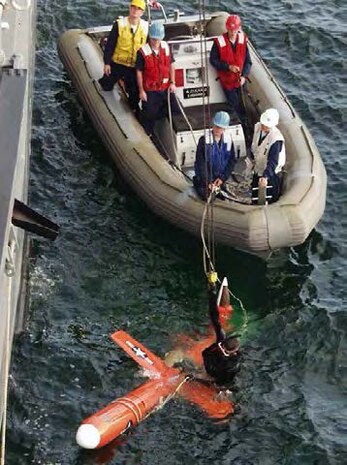 A U.S. Navy standard 7-meter Rigid-hull Inflatable Boat (RIB) performs dive exercises with a ship’s husbandry dive team, circa 2007 in the Atlantic Ocean. The RIB fleet integration began in the late 80s and continues today. (U.S. Navy photo provided by John “Jack” Mathias)