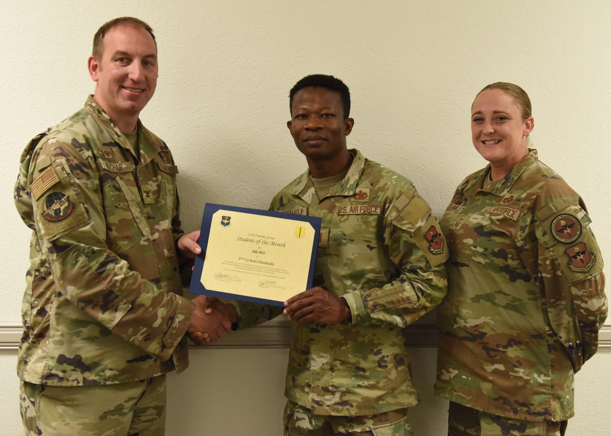 U.S. Air Force Col. Jason Kulchar, 17th Training Group commander, and Senior Master Sgt. Heather Celano, 313th Training Squadron senior enlisted leader, present the 315th Training Squadron Student of the Month award to 2nd Lt. Kofi Douhadji, 315th TRS officer student, at Goodfellow Air Force Base, Texas, August 12, 2022. Douhadji worked hard for his award and has shown his dedication to his squadron and the training he received at Goodfellow. (U.S. Air Force photo by Airman 1st Class Zachary Heimbuch)