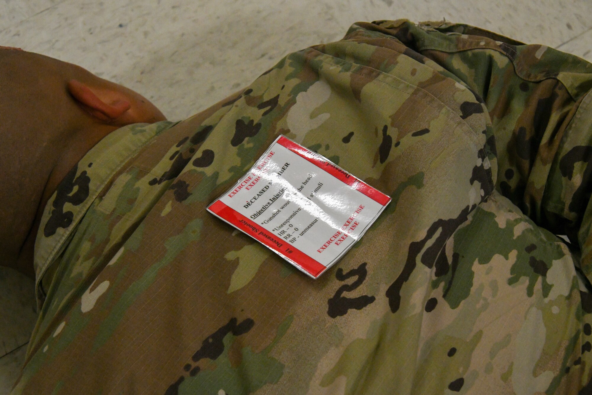 U.S. Air Force Airman Jose Ramirez, 97th Civil Engineer Squadron pavement and heavy equipment journeyman, lies on the ground during an active shooter exercise at Altus Air Force Base, Oklahoma, Aug. 8, 2022. Ramirez acted as the shooter and was detained by defenders from the 97th Security Forces Squadron. (U.S. Air Force photo by Airman 1st Class Miyah Gray)