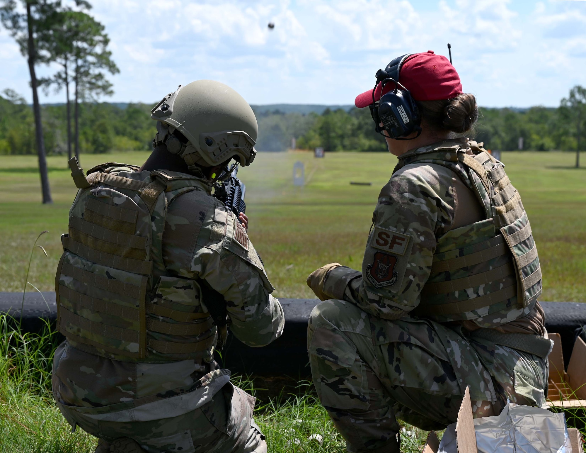 a person fires a weapon while another watches